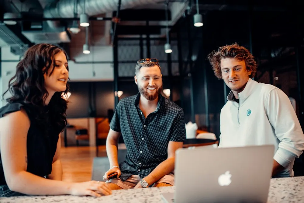Three colleagues reviewing search data together on a laptop